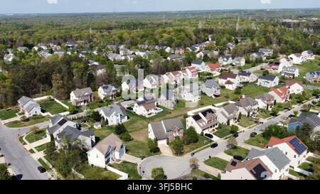 Moderne amerikanische Vorstadtgebiet mit Einzelhäusern, Solarpanelen auf dem Dach, ruhigen Wohnstraßen und grünen Frühlingslandschaften in den USA. Luftaufnahme Stockfoto
