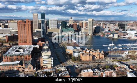 Luftbild von Stadthäusern in Baltimore mit Inner Harbor und Innenstadt-Skyline unter hellem Sonnenlicht, zeigt historische Backsteinarchitektur, Ufergegend und Stockfoto