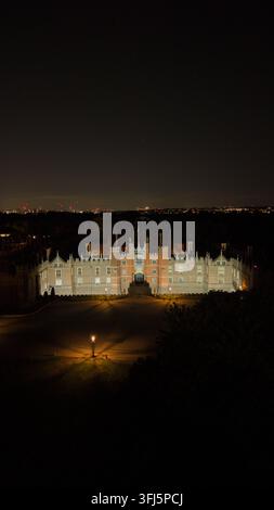 Hampton Court Palace, UK. 15. September 2026. Eine redaktionelle Nachtluftaufnahme, die das historische Hampton Court Palace im warmen Bogenlicht zeigt Stockfoto