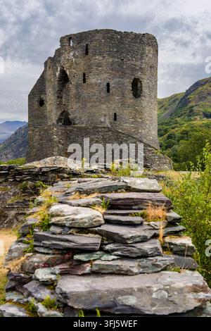 Dolbadarn Castle Steinkern in Llanberis, Snowdonia, Wales, mittelalterlicher runder Turm erhebt sich hinter verfallenen Schiefersteinmauern an einem bewölkten Tag Stockfoto