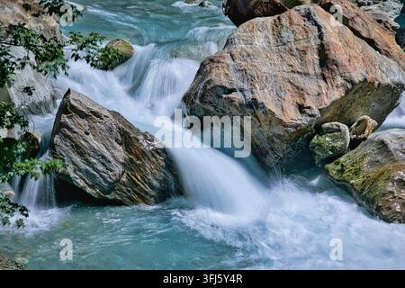 Ein fließender Fluss fließt zwischen großen Felsen und bildet einen kleinen Wasserfall, Wasser, fließend, Langzeitbelichtung, Gebirgsbach, Saaser Vispa, Saas Grund, Saa Stockfoto