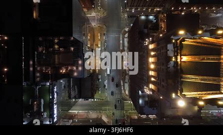 Top-Down-Luftnachtsicht der Innenstadt von Baltimore mit Stadtstraßenkreuzung, Verkehr, Polizeiautoslichtern und beleuchteter goldener Kuppel oben auf t Stockfoto