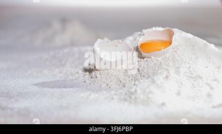 Eigelb liegt auf weißem Mehl in einer Küche Stockfoto