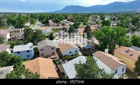 Häuser in einer Nachbarschaft in Colorado. Aufsteigende Luftaufnahme, die eine große Wohnsiedlung mit Blick auf die Rocky Mountains in der Ferne zeigt, Colorado Springs. Stockfoto