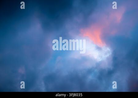 Dramatischer Himmel voller dunkler Wolken bei schlechtem Wetter vor einem großen Sturmregen mit einem hellblauen Himmel in der Mitte. Lichtemission vom Rand des Stockfoto