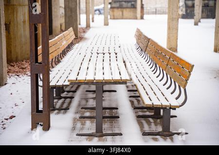 Im Freien stehende Bänke und lange Tische, die im Winter im Beijing 798 Art Zone mit Schnee bedeckt sind Stockfoto