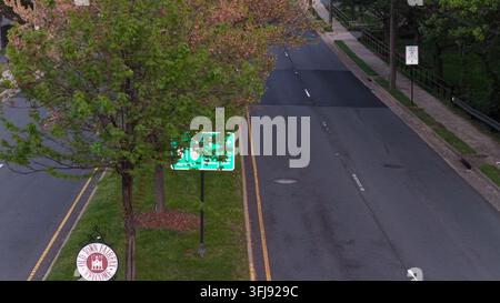 Luftbild einer Straße in Fairfax, Pennsylvania mit Willkommensschild, leerer Straße und grünen Bäumen im Frühling, das eine ruhige Vorstadtatmosphäre unter weichem Licht zeigt Stockfoto