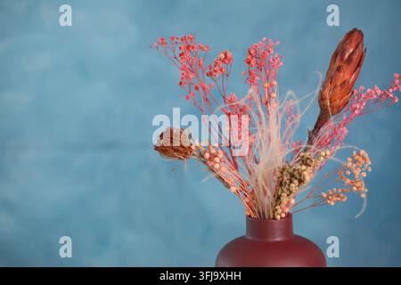 Schöne trockene Blumen in einer Vase auf hellblauem Hintergrund, Nahaufnahme. Platz für Text Stockfoto
