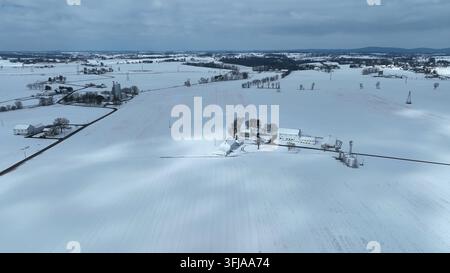 Drohne aus hohem Winkel zeigt eine verschneite Winterlandschaft mit Bauernhof, Rapho Township, Pennsylvania. Stockfoto