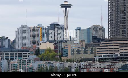 Der Säulenkopf des Space Needle erhebt sich über dichten Glaswohnblocken und mittigzeitlichen Betonbürogebäuden im bewölkten Stadtkern von Seattle. Stockfoto