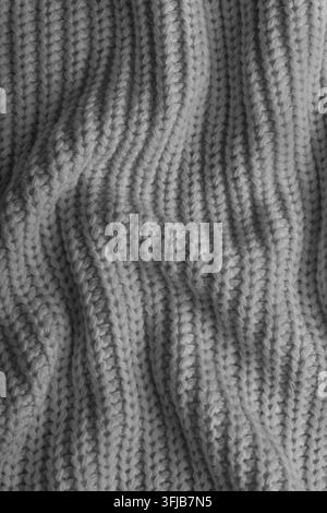 Nahaufnahme, Makro von zerknittertem grauem Strickstoff. Stoff mit sichtbaren Falten, Knitter und weichen Wellen. Weiche Wollmaterialtextur mit detailliertem s Stockfoto