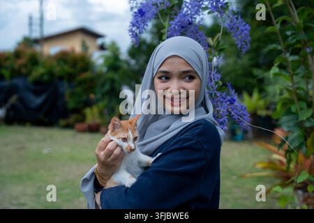 Fröhliche junge Frau mit orangefarbenem Ingwer-Kater Stockfoto