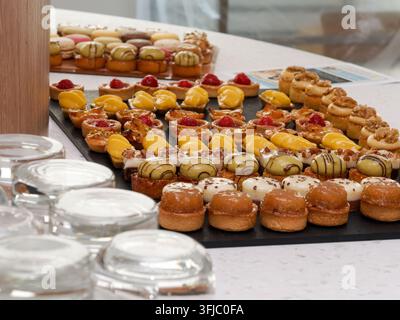 Verschiedene Miniaturgebäckstücke und glasierten Desserts auf einem Catering-Teller präsentiert Stockfoto