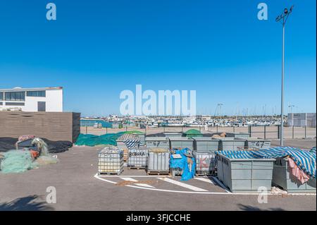 CHIPIONA, SPANIEN - 5. APRIL 2023: Blick auf den Hafen von Chipiona, Provinz Cadiz, Andalusien, Südspanien, mit Containern, die Angelausrüstung enthalten Stockfoto
