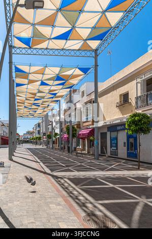 CHIPIONA, SPANIEN – 5. APRIL 2023: Blick auf eine gewerbliche Fußgängerzone in Chipiona, Provinz Cádiz, Andalusien, Südspanien, gesäumt von mehreren Schuhgeschäften Stockfoto