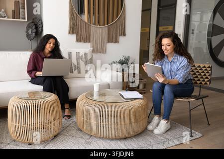 Zwei multikulturelle Kollegen, die remote an Unternehmensaufgaben in einem Coworking-Büro arbeiten Stockfoto