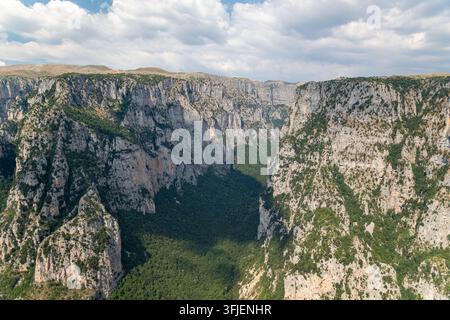 Die Vikos-Schlucht in Zagori, Epirus, Griechenland, zeigt dramatische Kalksteinklippen und eine bewaldete Berglandschaft. Stockfoto