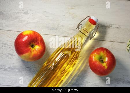 Hausgemachter Apfelessig in Glasflasche mit frischen Äpfeln Stockfoto