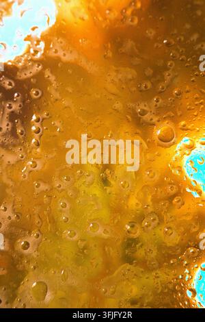 Eine Nahaufnahme von Blasen in einer schäumenden, bernsteinfarbenen kohlensäurehaltigen Flüssigkeit, die Bier oder Kwass ähnelt. Hochwertiges Foto Stockfoto