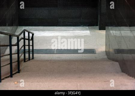 Hochwinkelaufnahme einer Steintreppe, die zu einem dunklen modernen Unterführung führt Stockfoto