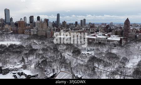 Ein atemberaubender Weitwinkel-Drohnenbild, das die schneebedeckten Bäume des Central Parks mit der ikonischen Skyline von Manhattan unter einem Winterhimmel einfängt, New York, New Stockfoto