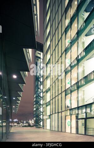 Beleuchtete moderne Glasbüros in More London in der Nähe der Tower Bridge leuchten bei Nacht und präsentieren schlanke zeitgenössische Unternehmensarchitektur. Stockfoto