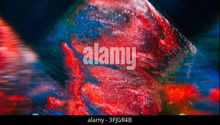 Unscharf fokussierte Marmorfarbe. Schimmernde Mischung. Blau-lila-rote Farbe, funkelnde optische Flüssigkeit, die sich auf abstrakter Kunsthintergrund ergießt. Stockfoto