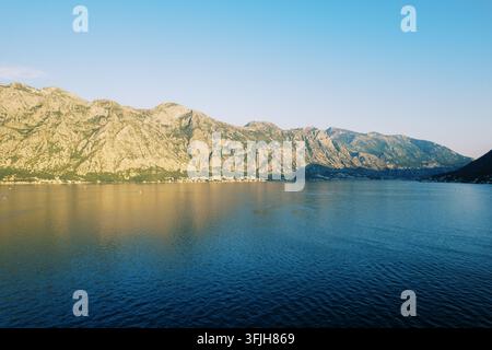 Sonnenbeschienene Berge und ruhige Bucht in Kotor, Montenegro Stockfoto