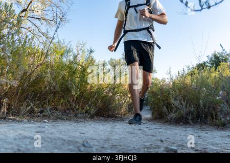 Mann beim Traillauf mit Rucksack auf staubigem Pfad Stockfoto
