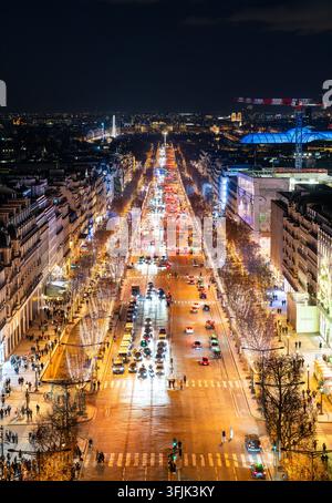 Paris, Frankreich - 04. Januar 2026: Nachtansicht des Verkehrs und der weihnachtlich beleuchteten Bäume entlang der Avenue des Champs-Elysées, gesehen vom Arc de Triomphe. Stockfoto