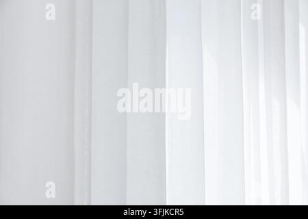 Minimalismus und Innendesign, weiche weiße Vorhänge mit natürlichem Sonnenlicht, das hindurchscheint, für eine friedliche Wohnatmosphäre und einen sauberen Wohnraum Stockfoto