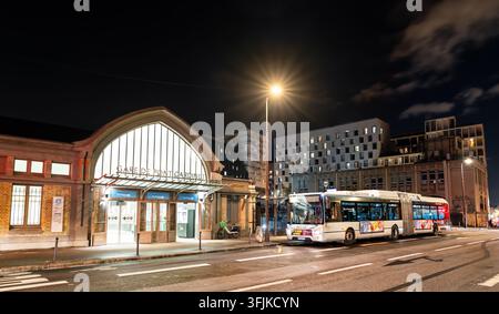 Paris, Frankreich – 04. Januar 2026: Außenfassade des Bahnhofs Gare de Pont Cardinet mit einem öffentlichen Verkehrsbus, der nachts auf der Straße geparkt ist. Stockfoto