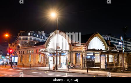 Paris, Frankreich – 04. Januar 2026: Außenfassade des Bahnhofsgebäudes Pont Cardinet, beleuchtet von Straßenlaternen bei Nacht im 17. Arrondissement. Stockfoto