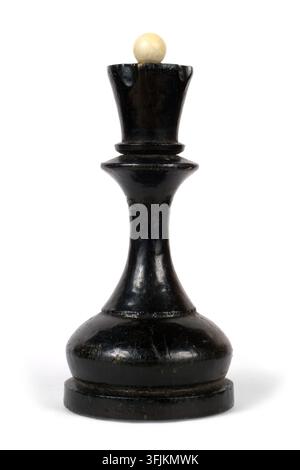Ein altes Schachspiel. Die schwarze Dame auf weißem Hintergrund. Holzschachfigur im Detail. Stockfoto