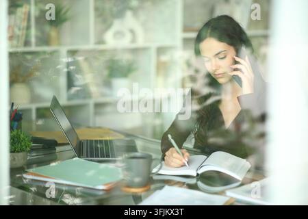 Junger Telearbeiter arbeitet online, nimmt an Anrufen teil und vereinbart Termine zu Hause Stockfoto