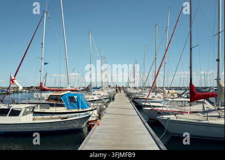 Segelboote, die entlang eines Holzstegs in einer Marina angelegt sind Stockfoto