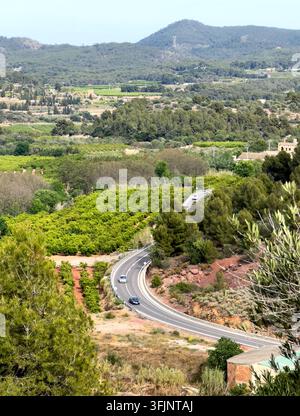 Windige Straße in den Hügeln im ländlichen Spanien, Luftaufnahme. Straße windet sich durch Berge mit fahrenden Autos, Drohnenaufnahme. Autos fahren auf windiger Straße durch Gr Stockfoto