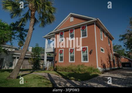 Tropisches Florida-Haus dekoriert mit roten Weihnachtskränzen Stockfoto