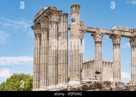 Blick auf den römischen Tempel von Évora mit seinen antiken korinthischen Säulen vor einem klaren blauen Himmel in Évora, Distrikt Évora, Portugal. Stockfoto