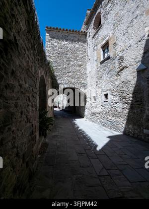 Schmale historische Gasse mit Steinbögen und alten Gebäuden im Sonnenlicht und Schatten Stockfoto