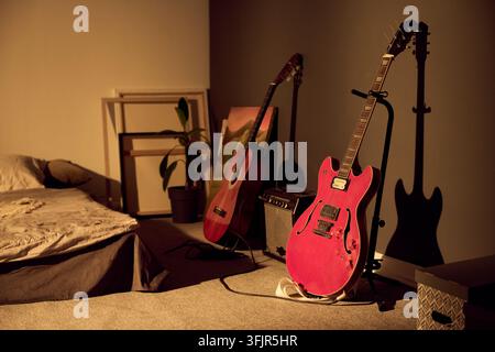 E-Gitarre mit Akustikgitarre im gemütlichen Schlafzimmerstudio Stockfoto