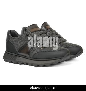 Paar dunkelgraue Sneaker mit strukturiertem Stoffobermaterial, Lederpaneelen, mehreren Riemchen und robusten Profisohlen auf weißem Studiohintergrund. Stockfoto