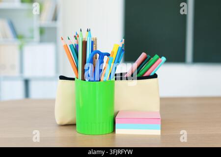 Schreibzeug auf einem Holztisch im Klassenzimmer, Nahaufnahme Stockfoto