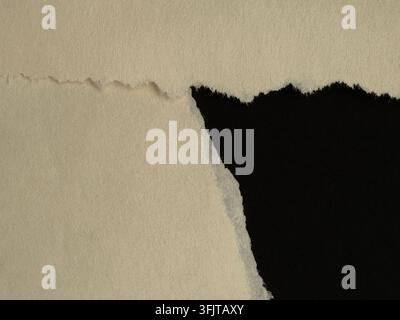 Beiger abgenutzter Papierrand legt einen tiefschwarzen Hintergrund frei und erzeugt eine dramatische Enthüllung mit rauen Fasern und einer strukturierten Oberfläche. Ideal für Overlays, Hintergrund Stockfoto