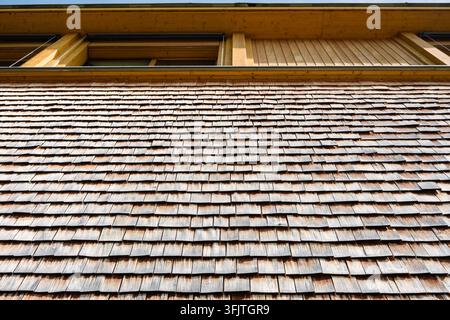 Holzschindeln aus Brettern werden verwendet, um die Dächer und Außenwände von Häusern in der Schweiz zu bedecken. Stockfoto