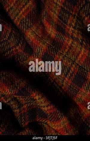 Dunkler karierter Wollstoff im Tartan-Muster als Nahaufnahme-Hintergrund. Stockfoto
