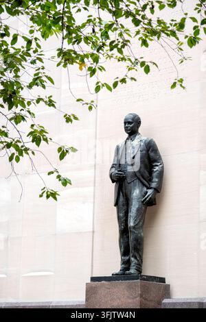 Robert Taft-Denkmal in Washington DC | WASHINGTON — Die Bronzestatue von Sen. Robert A. Taft steht unter Baumästen am Fuße des Robert A. Taft Memorial and Carillon auf dem Gelände des US-Kapitoliums, fotografiert in Washington, D.C., im September 2026. Das Denkmal befindet sich an der Constitution Avenue zwischen der New Jersey Avenue und der First Street NW, unter der Aufsicht des Architekten des Kapitoliums. Der Architekt Douglas W. Orr entwarf den fast 100 Fuß (30 m) hohen Schacht aus hellem Tennessee-Marmor hinter der Statue, und der Bildhauer Wheeler Williams modellierte die Bronzestatue an ihrem Fuße. Eine Widm Stockfoto
