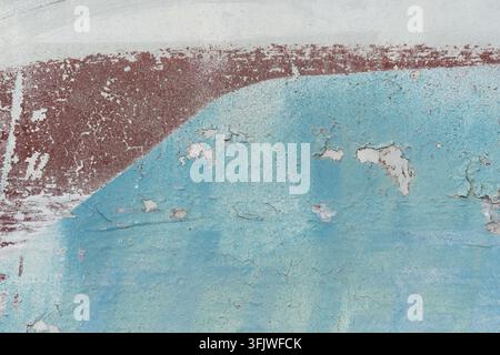 Abblätternde blaue Farbe auf einer strukturierten Wandoberfläche Stockfoto
