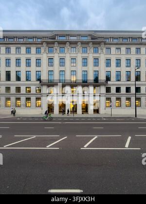 Menschen gehen und radeln am Eingang der Cleveland Clinic London am 33 Grosvenor Place vorbei, während sie die Straße entlang pendeln. Stockfoto