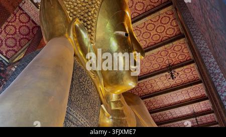 BANGKOK, THAILAND - 20. SEP 2026: Eine Nahaufnahme des ruhigen goldenen Gesichts der riesigen liegenden Buddha-Statue im Wat Pho Tempel in Bangkok Stockfoto